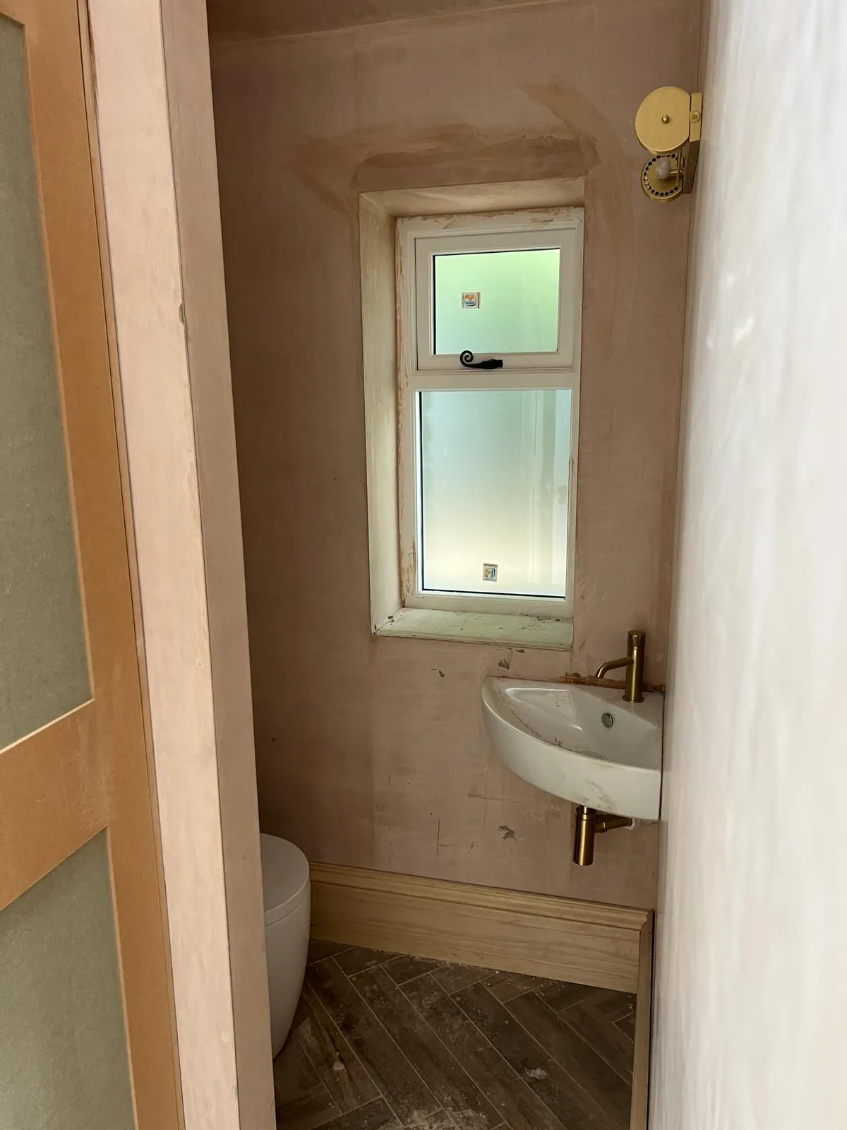 A bathroom with a sink, toilet and a window.