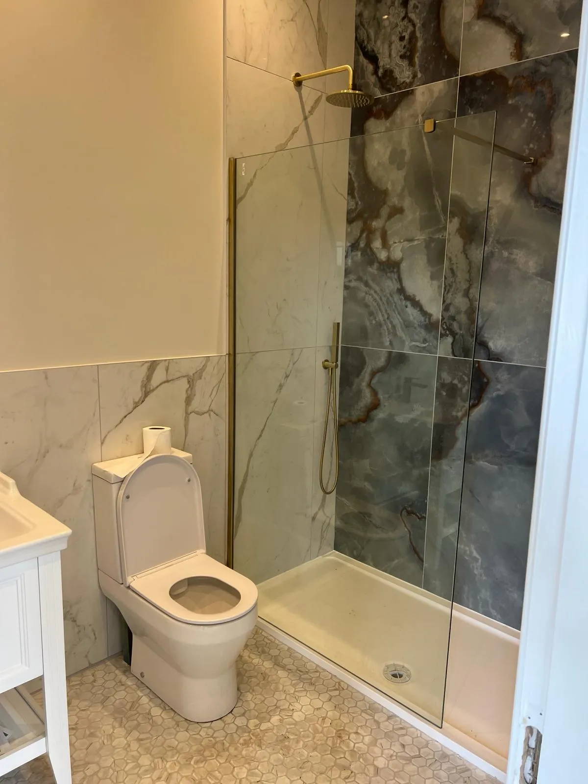 A white toilet sitting next to a walk in shower.