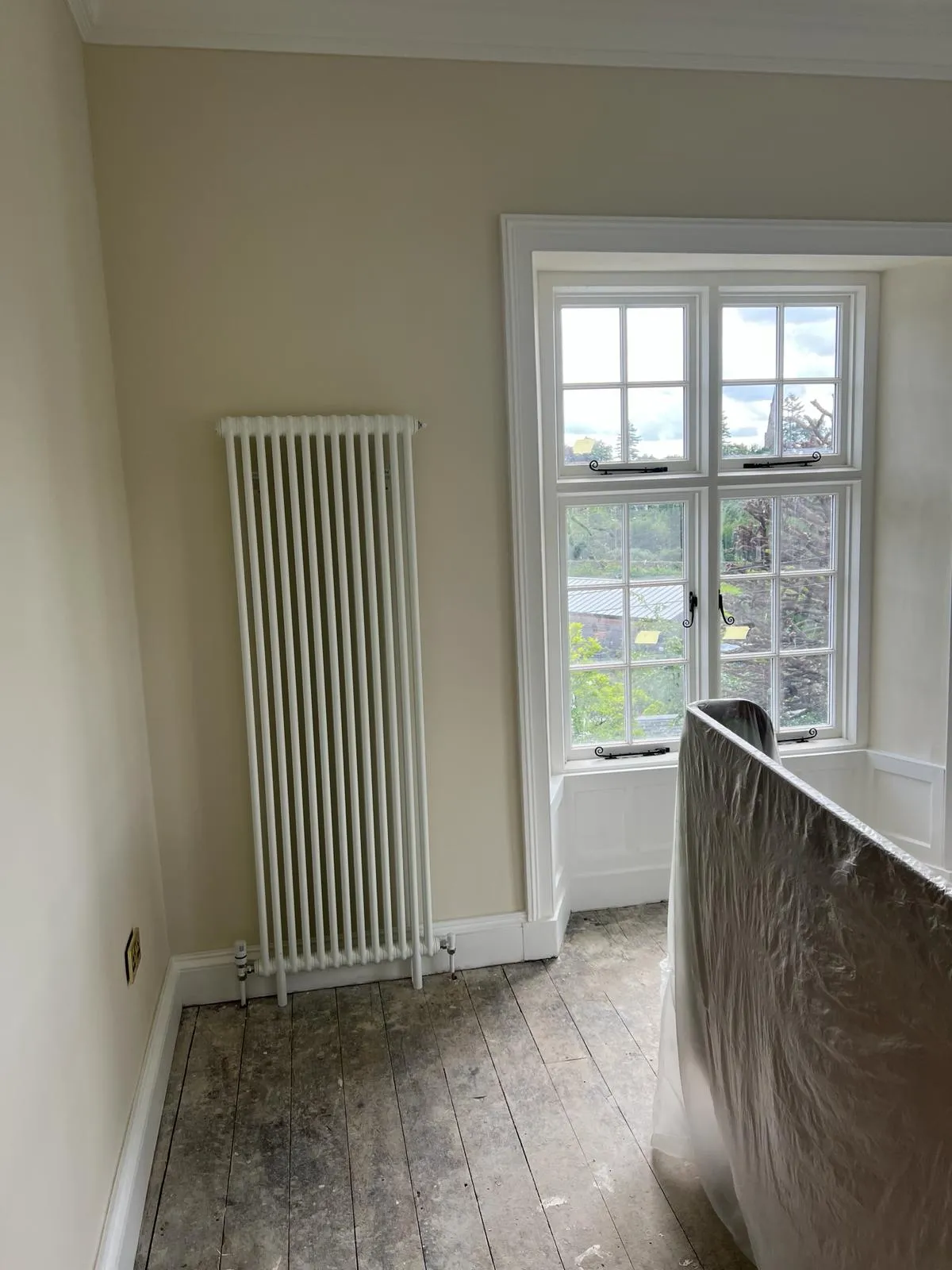 A bathroom with a radiator and a window.
