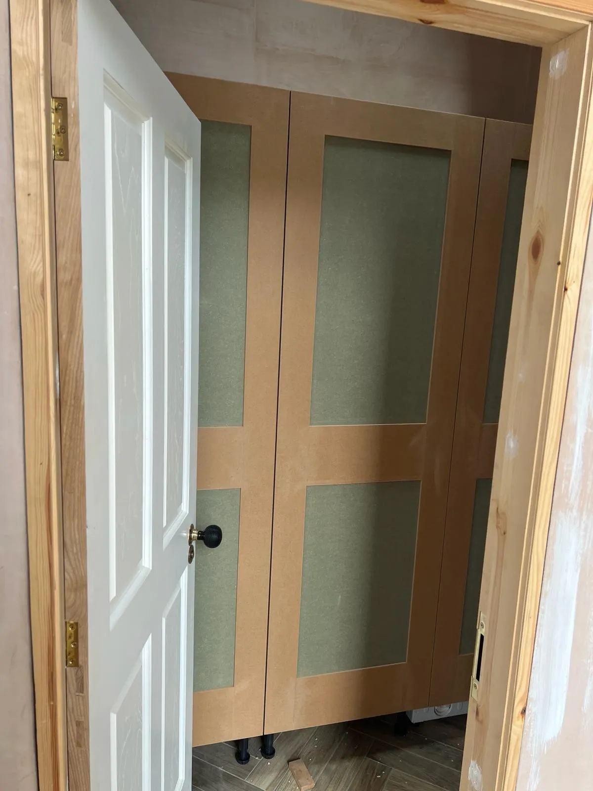 A room with two doors and a hard wood floor.