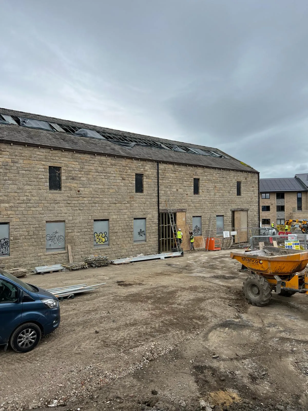 A blue car parked in front of a building.