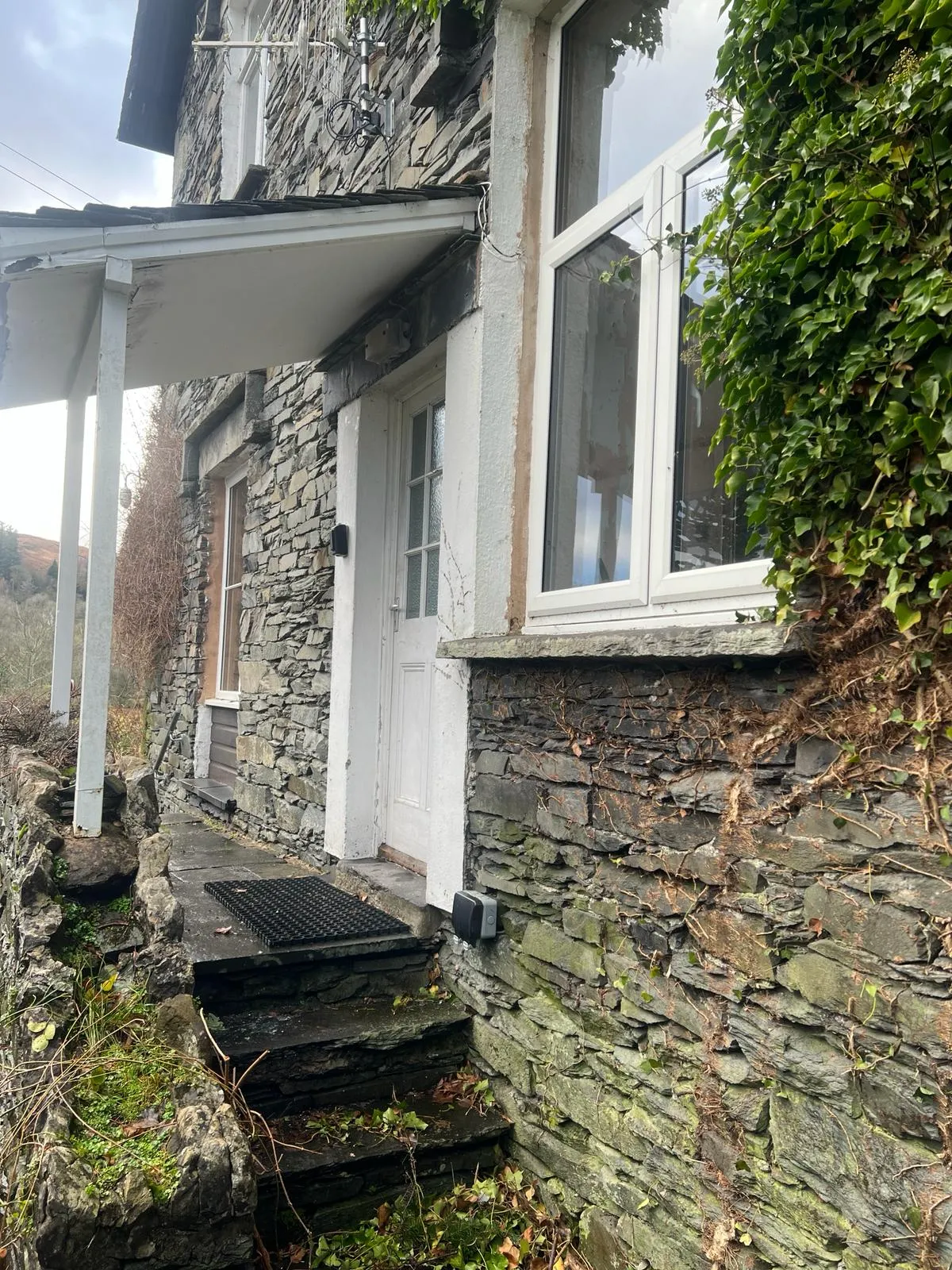 A stone house with a white door and windows.