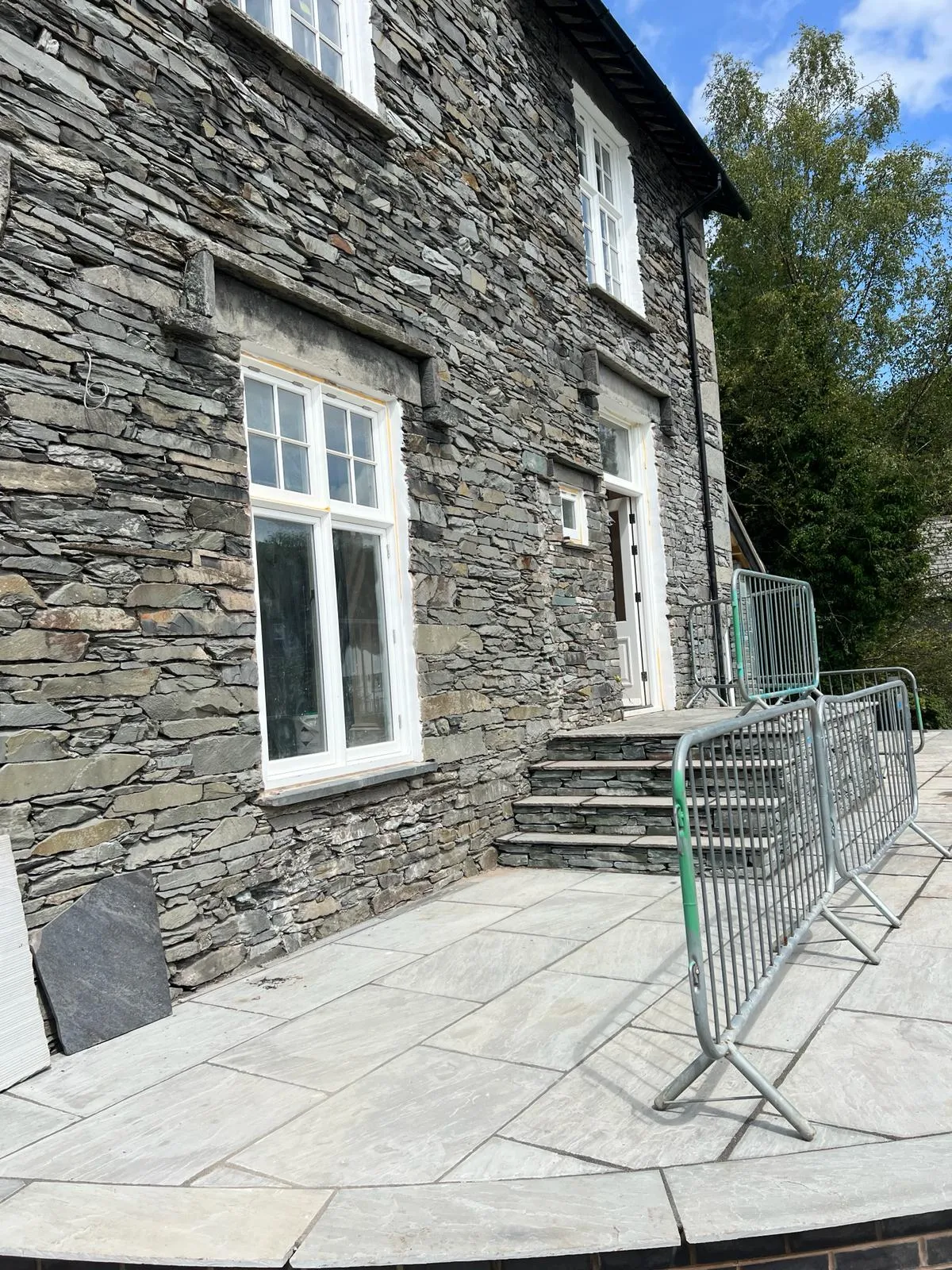 A shopping cart sitting in front of a stone building.