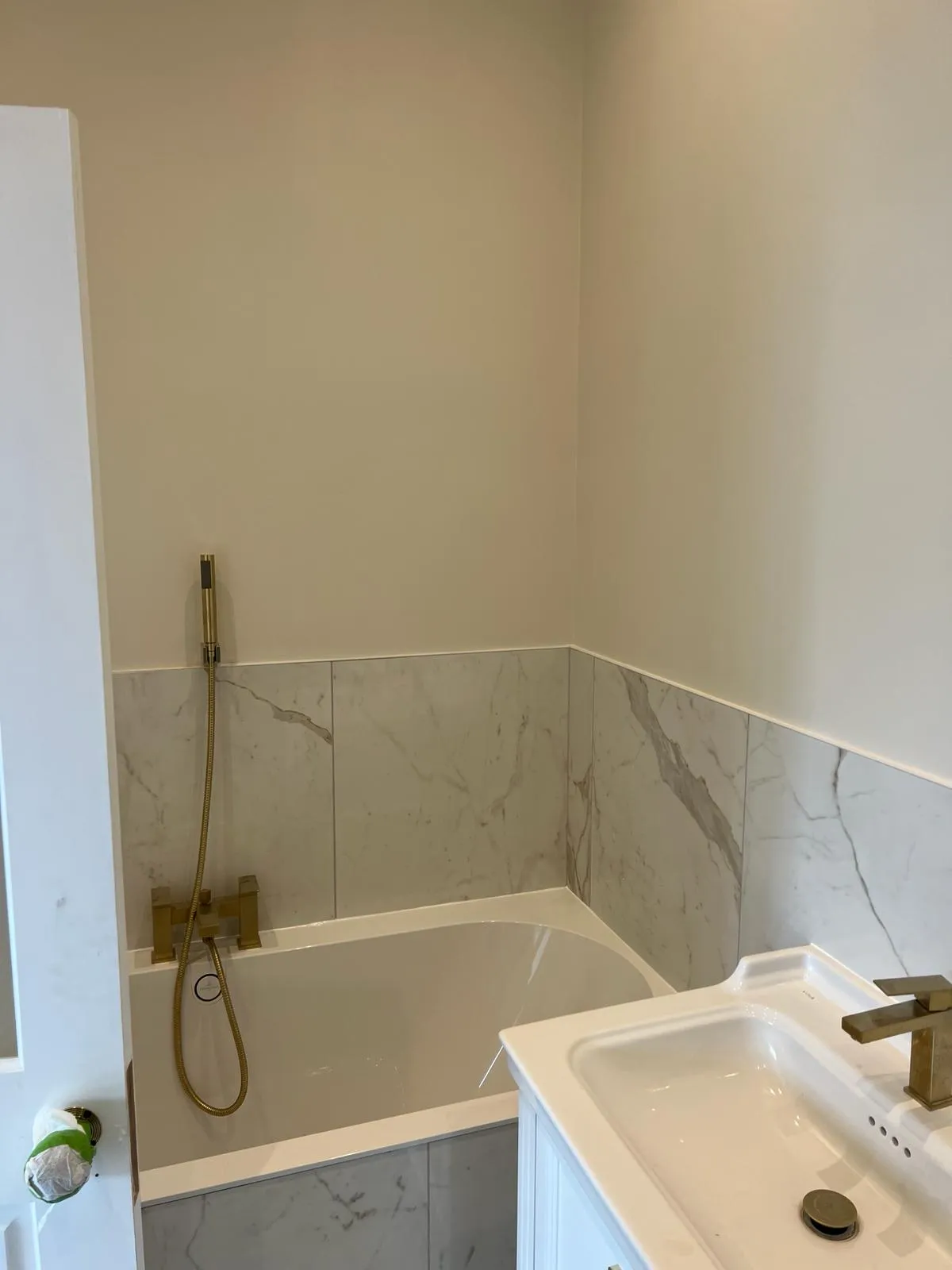 A bathroom with a sink, tub and shower head.