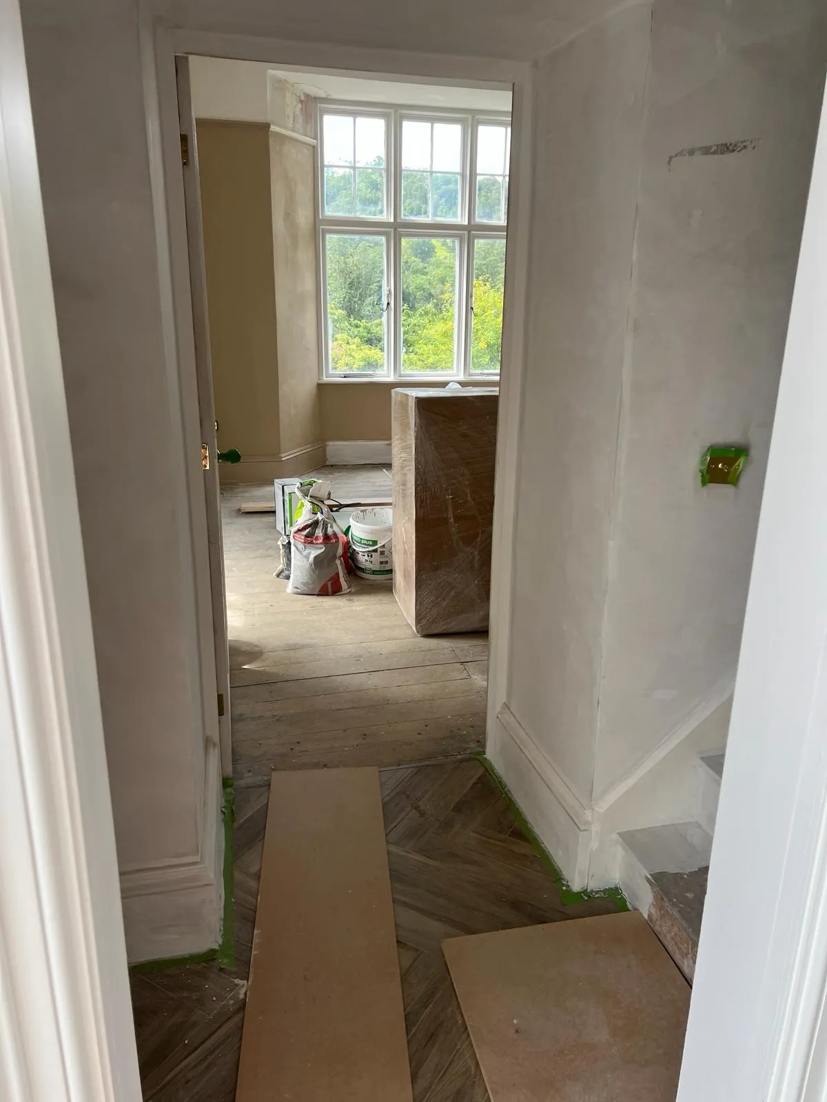 A room with a window and a box on the floor.