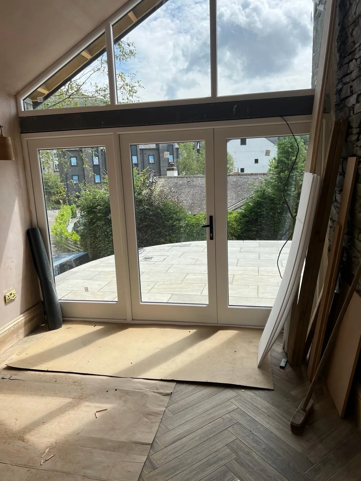 A room with a large glass door and a brick wall.